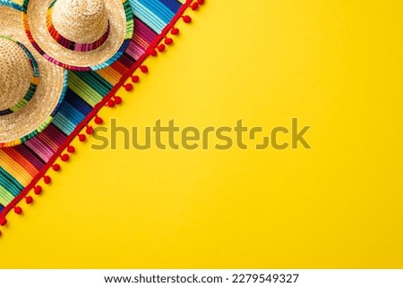 Mexican traditional costume concept. Top view photo of sombrero hats and colorful striped serape on isolated vivid yellow background with copyspace