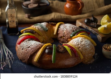 Mexican traditional rosca de reyes with fig, orange, Oaxaca chocolate and powdered sugar with a clay jarrito on a jute sack in the background for the día de los Reyes Magos celebration on january 5th