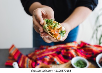 Mexican woman hands preparing tacos al pastor with sauce in Mexico city
