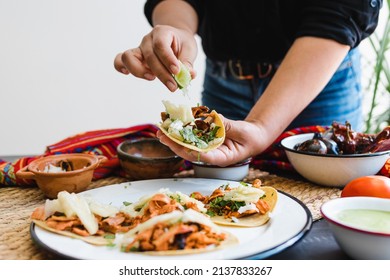 Mexican woman hands preparing tacos al pastor with sauce. traditional food in Mexico Latin America