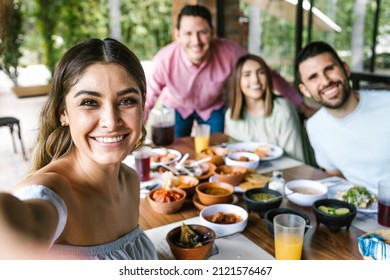 Mexican woman taking a photo selfie with group of latin friends and eating mexican food in restaurant terrace in Mexico Latin America - Shutterstock ID 2121576467