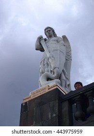 Mexico City, Mexico- 17JUL2010:St. Michael the Archangel statue at the Shrine of Our Lady of Guadalupe (Mexico City) against foreboding sky; flanked by the face of a small boy peering over a balcony.