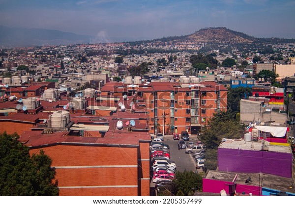 Mexico City, Mexico - April 17, 2022: View of an\
apartment complex in the Iztapalapa neighborhood in Mexico City\
from the cablebús, an gondala lift, and part of the city public\
transportation system 