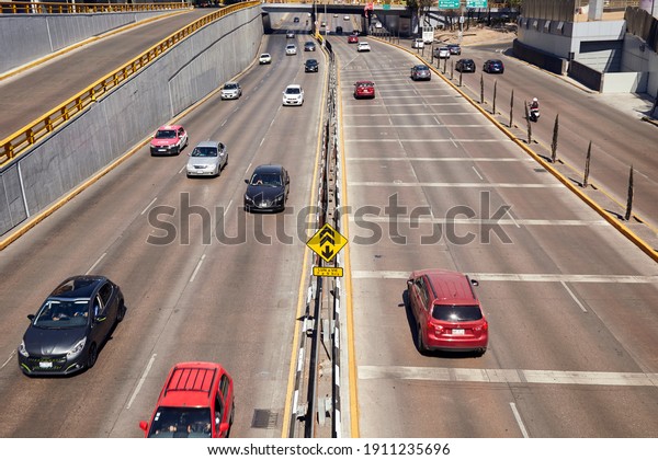 Mexico City, CDMX, Mexico 02-06-2021\
Cars circulating in light traffic over Melchor Ocampo Avenue (known\
as Circuito Interior) on a beautiful sunny\
day.