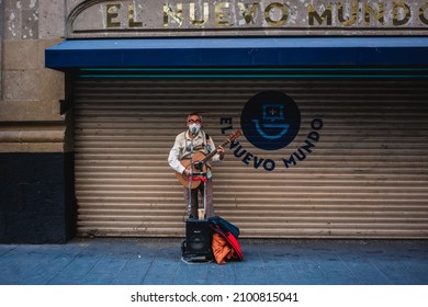 Mexico City, Mexico; January 04 2022: street musician in front of the façade of a nightlife venue in the afternoon. people of Mexico.