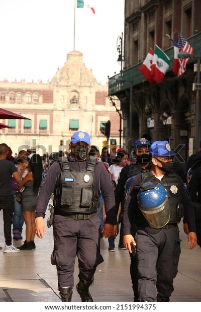 Mexico City, Mexico – June 08, 2020: Policeman in\
blue roaming the city during the day wearing face masks and extra\
protection face shields