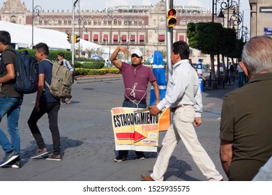 Mexico City, Mexico, September 01, 2018: Man In Charge Of The Parking Lot In The Plaza Of Mexico City Pointing The Direction And With People Walking Around. Travel Concept