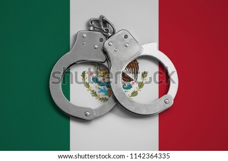 Mexico flag  and police handcuffs. The concept of observance of the law in the country and protection from crime