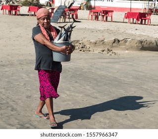 Mexico, Oaxaca, Puerto Escondido -12 November 2019: Indigenous Woman Returns Home With A Bucket Full Of Fish,bucket With Fish Tails That Emerge, Full Color