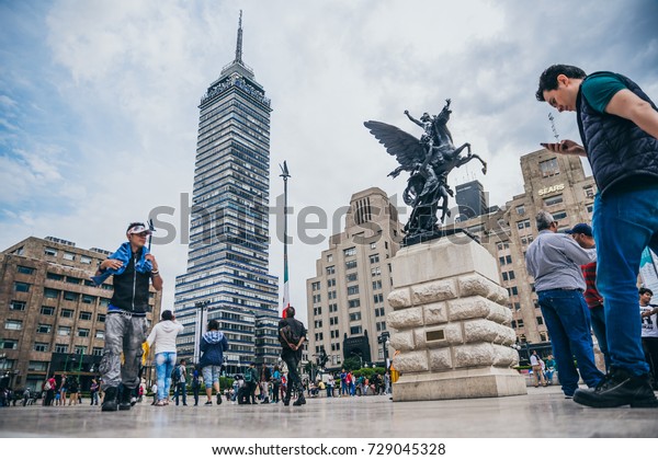 MEXICO - SEPTEMBER 20: Crowd of\
people at the Palace of Fine arts plaza with the latin american\
tower in the background, September 20, 2017 in Mexico City,\
Mexico