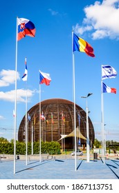 Meyrin, Switzerland - September 7, 2020: The Globe of Science and Innovation at CERN, the European Center for Nuclear Research, with the flags of the member states flying against blue sky.