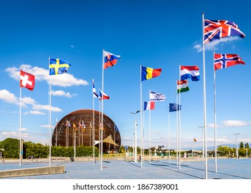 Meyrin, Switzerland - September 7, 2020: The Globe of Science and Innovation at CERN, the European Center for Nuclear Research, with the flags of the member states flying against blue sky.