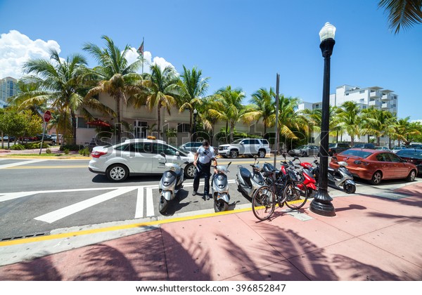 MIAMI - AUGUST 23, 2014: Miami Parking\
officer and his car parked near South beach.\
