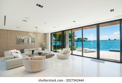Miami Beach - April 2019: Modern living area with wide views of the bay and city. Beautiful minimalist white interior