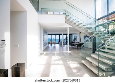 Miami Beach - April 2019: Modern foyer of luxury contemporary home, with staircase leading to 2nd floor. Living area visible in the back.