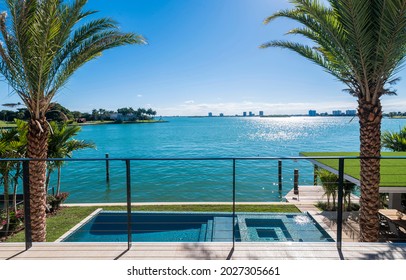 Miami Beach - April 2019: View of a nice pool and waterfront from terrace of a luxury home.