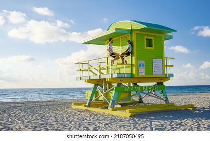 Miami Beach, a couple on the beach at Miami Florida, lifeguard hut Miami Asian women and caucasian men on the beach during sunset. man and woman watching sunrise - Powered by Shutterstock