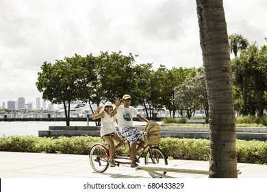 MIAMI BEACH, FL - July 15th, 2017: Happy Couple On Tandem Double Bike South Pointe Walkway