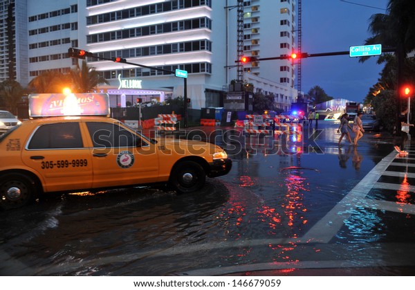 MIAMI BEACH, FL - JULY 18: Cars\
moving on flooded streets and roads of Miami South Beach  after\
heavy rains in Florida July 18, 2013 in Miami Beach,\
Florida