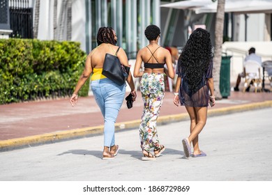 MIAMI BEACH, FL, USA - DECEMBER 7, 2020: Attractive young black women walking on Ocean Drive Miami Beach rear view