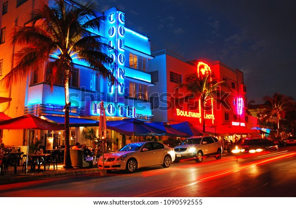 Miami\
Beach, FL, USA November 20 Cars cruise past the bright neon lights\
and Art Deco buildings in Miami Beach,\
Florida