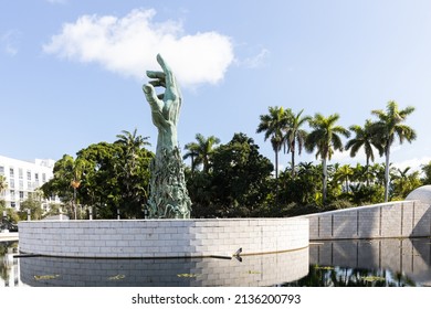 MIAMI BEACH, FL, USA - OCTOBER 14, 2019: The Holocaust Memorial In Miami Beach Features A Reflection Pool With A Hand Reaching Up And Bodies Climbing,  A Memorial Wall, And Memorial Bridge.