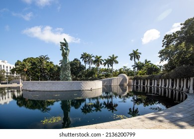 MIAMI BEACH, FL, USA - OCTOBER 14, 2019: The Holocaust Memorial In Miami Beach Features A Reflection Pool With A Hand Reaching Up And Bodies Climbing,  A Memorial Wall, And Memorial Bridge.