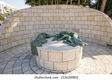 MIAMI BEACH, FL, USA - OCTOBER 14, 2019: The Holocaust Memorial In Miami Beach Features A Reflection Pool With A Hand Reaching Up And Bodies Climbing,  A Memorial Wall, And Memorial Bridge.