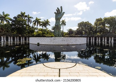 MIAMI BEACH, FL, USA - OCTOBER 14, 2019: The Holocaust Memorial In Miami Beach Features A Reflection Pool With A Hand Reaching Up And Bodies Climbing,  A Memorial Wall, And Memorial Bridge.