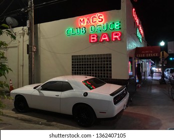 Miami Beach, FL/USA - April 6th 2019: Exterior Shot Of Mac's Deuce Bar With, One Of The Oldest Bars And A Local Institution In The Heart Of South Beach. A Dodge Challenger Is Parked In The Foreground