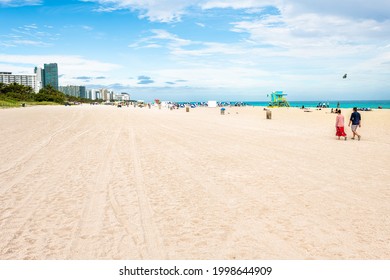 Miami Beach, USA - January 17, 2021: South Beach. Florida With People Walking On Beach And Apartment Condo Hotel Buildings And Sand