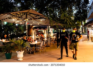 Miami Beach, USA - January 20, 2021: Famous Lincoln Road Shopping Street With People Walking On Sidewalk By Restaurant Cafe At Night In Masks Covid-19