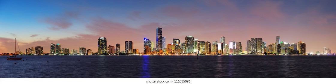 Miami City Skyline Panorama At Dusk With Urban Skyscrapers Over Sea With Reflection