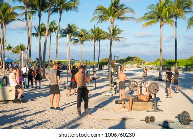 MIAMI - DECEMBER 27, 2017: Muscular Young Men Work Out At The Outdoor Fitness Station Known Locally As Muscle Beach South Beach, Which Attracts Onlookers Passing On The Lummus Park Promenade.