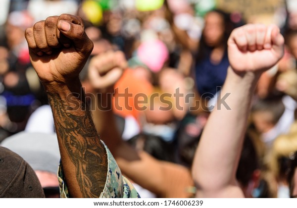Miami\
Downtown, FL, USA - MAY 31, 2020: Hands of white and black people\
during a protest against racism in\
America
