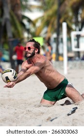 MIAMI, FL - DECEMBER 27:  A man lunges into the sand to dig the ball in a recreational pickup game of beach volleyball on a public beach off Ocean Drive on December 27, 2014 in Miami, FL.
