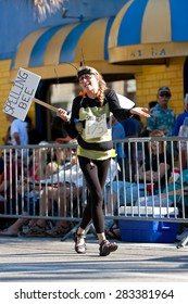 MIAMI, FL - DECEMBER 28:  A Senior Woman Wears A Bumble Bee Costume And Holds A 