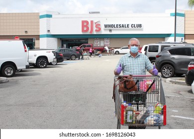 Miami, Fl / USA - April 6, 2020: An Older Hispanic Man Wearing Protection Gloves And A Face Mask After Shopping At BJ's Wholesale Club Store During The Coronavirus COVID-19 Outbreak In The Miami Area.