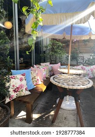 Miami, Fl, USA: March 3, 2021: Vintage Outdoor Patio Decertations For A Tea Party At A Bridal Shower. Sun Shining Through. Fancy Floral Pillows In An Upscale Restaurant In Miami Called Little Hen.