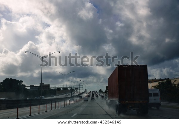 Miami\
Florida rainy driving road with trucks\
traffic