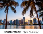 Miami, Florida skyline and bay at sunset seen through palm trees 
