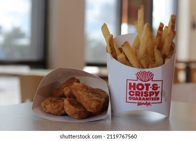 MIAMI, FLORIDA USA - 02-03-2022 
Chicken Nuggets And French Fries At A Wendy's Restaurant. Out Of Focus Restaurant Interior As Backdrop.