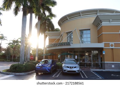 MIAMI, FLORIDA USA - 06-18-2022
Early morning sun shining through palm trees at exterior of a Starbucks restaurant in Miami, Florida.