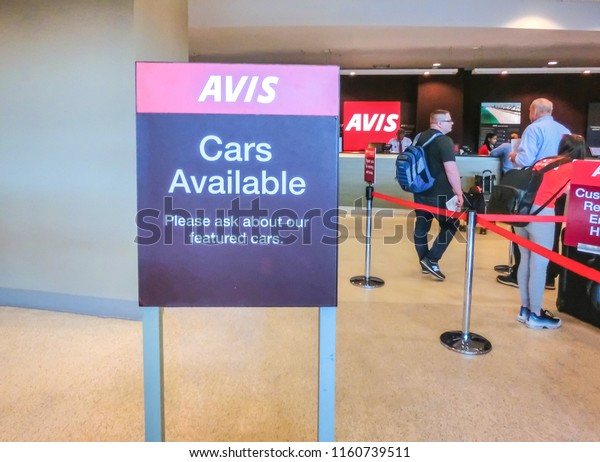 Miami, Florida, USA - Aprile 28, 2018: The people\
near Avis rental car office at Miami airport at Miami, Florida, USA\
on Aprile 28, 2018