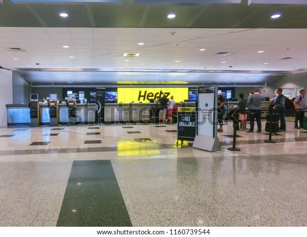 Miami, Florida, USA - Aprile 28, 2018: The people\
near Hertz rental car office at Miami airport at Miami, Florida,\
USA on Aprile 28, 2018
