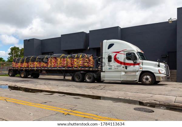 Miami, Florida, USA - July\
26, 2020: Long open cargo truck with potato shipment parked for\
drop off