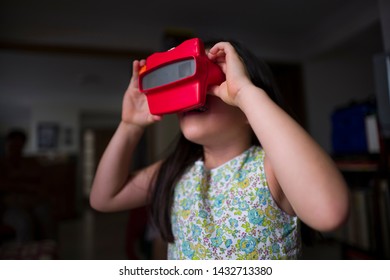 Miami, Florida/USA-03/16/2019: Girl Viewing Towards The Light, Tiny Transparent Reels Of 3-D Film Color Photographs Using A Special Format Of Sliding Cardboard Disks On A Stereoscopic Viewfinder Toy 