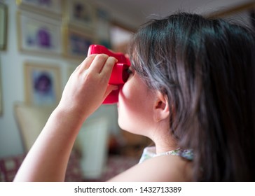 Miami, Florida/USA-03/16/2019: Girl Viewing Towards The Light, Tiny Transparent Reels Of 3-D Film Color Photographs Using A Special Format Of Sliding Cardboard Disks On A Stereoscopic Viewfinder Toy 