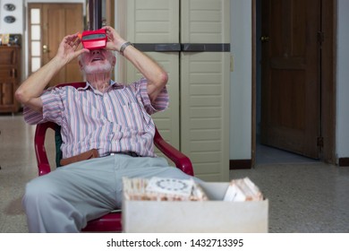 Miami, Florida/USA-03/16/2019: Senior Man Viewing Towards The Light, Transparent Reels Of 3-D Film Color Photographs Using A Special Format Of Sliding Cardboard Disks On A Stereoscopic Viewfinder Toy 