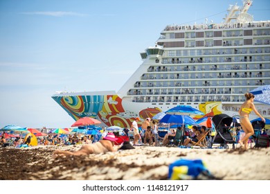 MIAMI - JUNE, 2018: The Norwegian Getaway cruise ship, which scores a C for air pollution reduction, towers above sunbathers on South Beach as it departs PortMiami.